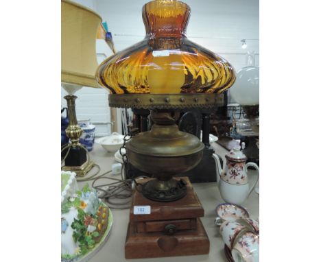 A vintage brass oil lamp on a treen base with an amber brass shade