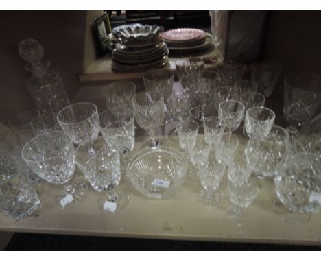 A shelf of cut glass drinking glasses and decanter