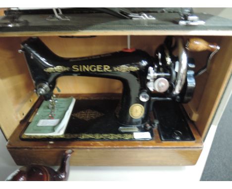 A Singer no.99 hand cranked sewing machine in case with instruction manual