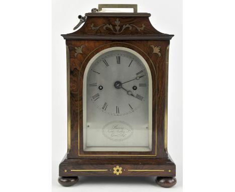 A Regency/William IV rosewood and brass inlaid mantel clock by Purvis. The case of architectural design with pierced brass si