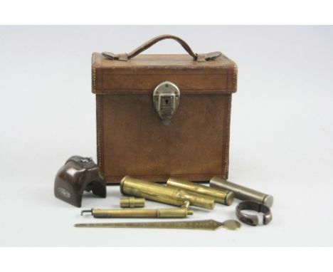 A WWI ERA BROWN LEATHER RECTANGULAR CARRY BOX, containing various tools and calibration devices for use with barrelled weapon