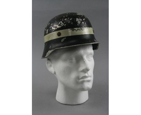 A WWI ERA GERMAN LIGHT WEIGHT METAL HELMET, possibly used by German fire/Police Service, the helmet is black but is missing l