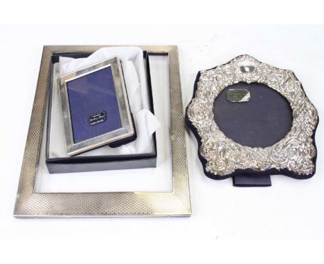 An Elizabeth II silver clad easel photograph frame, having a plain cartouche amongst cherub repoussee decoration, height 18cm