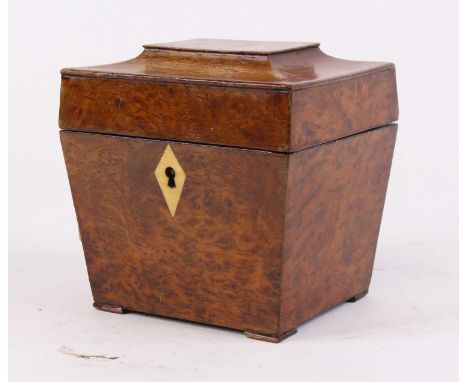 A George III burr walnut tea caddy of sarcophagus form, having a kite shaped ivory escutcheon, the lid lifting to reveal a si