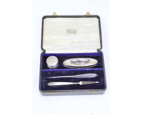 A George V lady's silver mounted four-piece manicure set, having engine turned decoration, in fitted Harrod's of London case;
