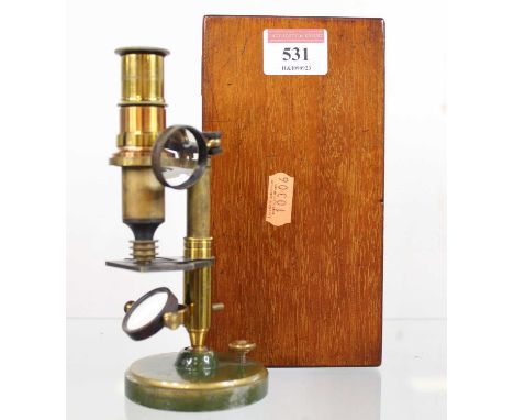 A 19th century brass monocular microscope, having a mahogany case and some slides, height of microscope 15cm