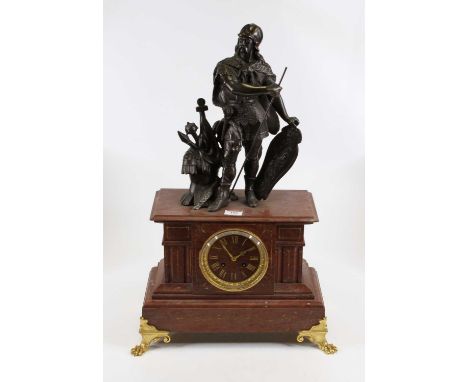 A 19th century rouge marble mantel clock, the dial showing gilt Roman numerals, having an eight day movement, the case surmou