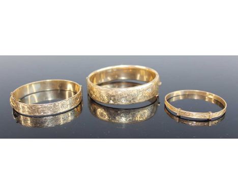 A Victorian style rolled gold hinged bangle, having flower engraved decoration and safety chain, dia.66mm; together with two 