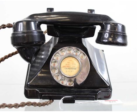 A vintage bakelite rotary telephone and wall bracket