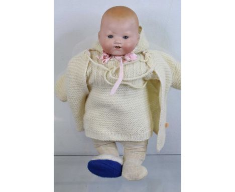 A vintage bisque headed doll, impressed Kammer and Reinhardt for Simon &amp; Halbig to the neck, having blue glass eyes, and 
