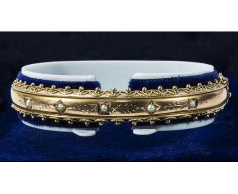 A Victorian 9ct gold bangle set with seed pearls, weight 12gms