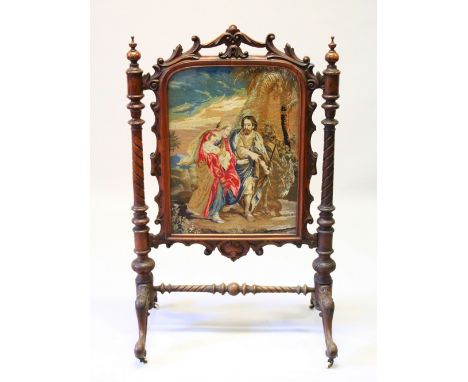 A VICTORIAN MAHOGANY FIRE SCREEN with Berlin tapestry, on curving legs. 116cms high x 74cms wide.