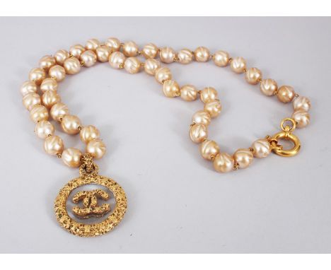 A CHANEL PEARL NECKLACE, with gilt metal and glass double-sided logo pendant.
