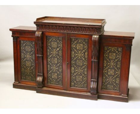 A GOOD REGENCY MAHOGANY BREAKFRONT SIDE CABINET, the top with raised shelf over four panel doors with gilded leather, enclosi