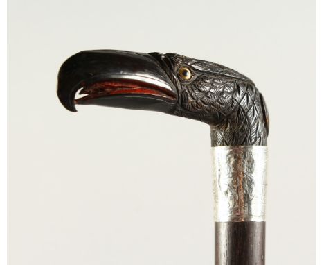 A VICTORIAN WALKING STICK, with carved birds head initialled RN, with engraved silver band. 83cms long.