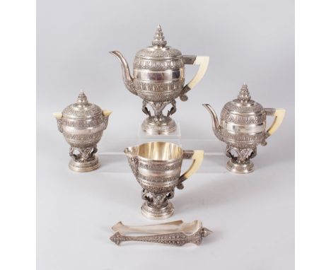 A SUPERB BURMESE SILVER FIVE PIECE TEA SET, with all-over decoration and ivory handles, comprising two various teapots, sugar