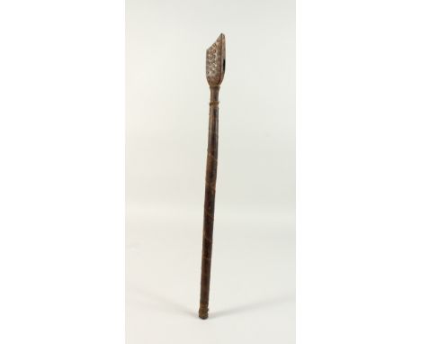 A TRIBAL TOOL HANDLE, POSSIBLY MAORI, with circular decoration and metal wire banding. 55.5cms.