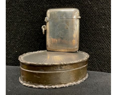 An Edwardian silver oval trinket box, engine turned hinged cover, Birmingham 1904;  silver and silver gilt vesta case, Birmin