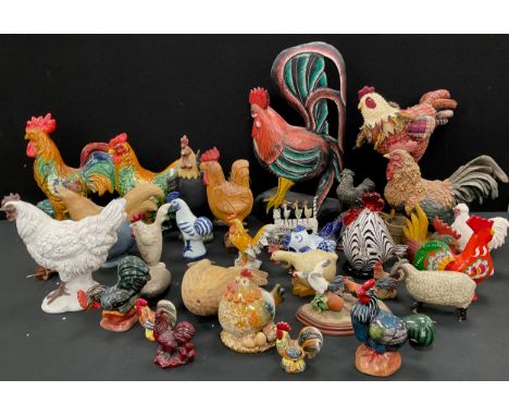 Large quantity of ceramic, carved wood, and glass cockerel and hen models, largest measuring 49cm height, 27cm width.
