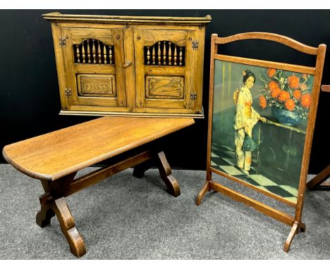 An oak wall mounted cupboard, 51.5cm high x 81.5cm wide x 19.5cm deep;  an oak coffee table;  oak fire screen, mid 20th centu