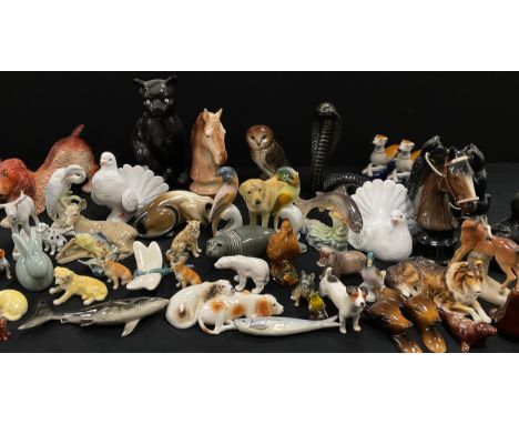 A collection of model ceramic animals including; a pair of Staffordshire style greyhounds, cats, dogs, sea lions; etc.