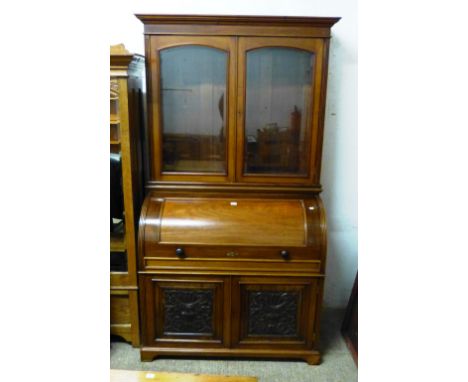 A late 19th century mahogany cylinder fronted bureau/bookcase, with pullout writing surface, fitted interior, carved panelled