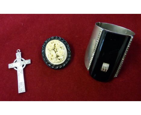 A silver Celtic cross pendant, a Victorian carved ivory floral brooch set in a jet mount and an Art Deco resin and paste cuff