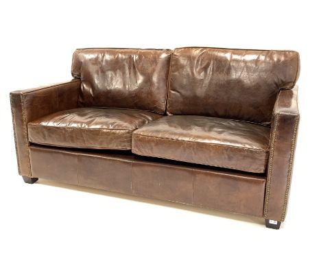  Contemporary two seat sofa upholstered in brown leather, raised on block supports, W172cm, H74cm, D101cm   - Condition Repor