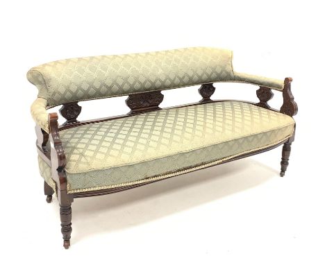  Late Victorian carved walnut framed three seat salon sofa, upholstered in patterned green fabric, raised on turned supports 