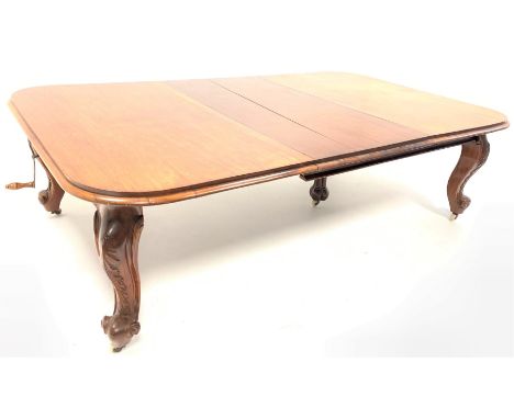  Large Victorian walnut extending dining table, the moulded top with 'D' shaped ends raised on leaf carved and scrolled suppo