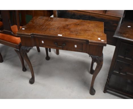 A George III carved mahogany fold-over card table, the hinged and shaped rectangular top lifting to reveal the baize playing 