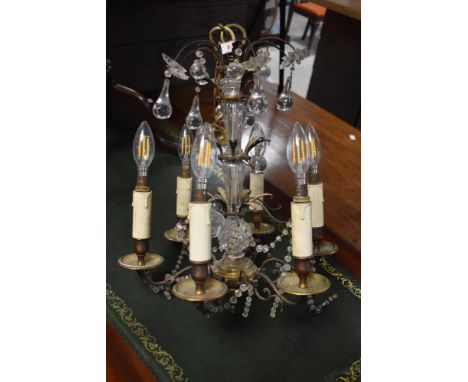 A brass and glass six branch electric chandelier light fitting , with suspended drops and faux candle fittings