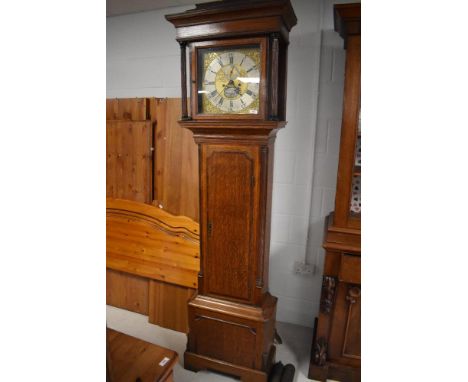 A George III oak eight day long case clock, the flat topped hood with ogee surmount over the square glazed hood door and flut