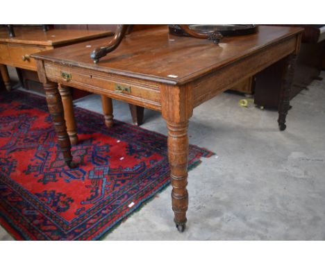 A Victorian oak library table, of rectangular form with long drawer to each end and raised on turned supports finishing with 