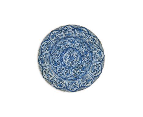A Chinese blue and white charger, Kangxi period (1662-1722), painted to the centre with foliage and lotus, within a panelled 