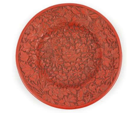 An unusual Chinese cinnabar lacquer ‘thousand flower’ footed dish, 18th/19th century, finely carved in high relief to the int