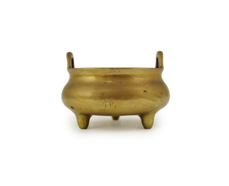 A Chinese bronze censer, ding, Xuande mark, 18th/19th century, surmounted by a pair of high looped handles, on three tapered 