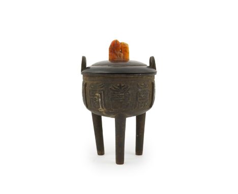 A Chinese bronze tripod censer and cover, ding, late Ming Dynasty, with twin upright handles, the body decorated with large a