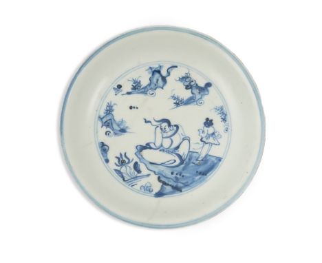 A Chinese Ming blue and white saucer dish, 16th century, the centre painted with a seated immortal and attendant on a rocky o