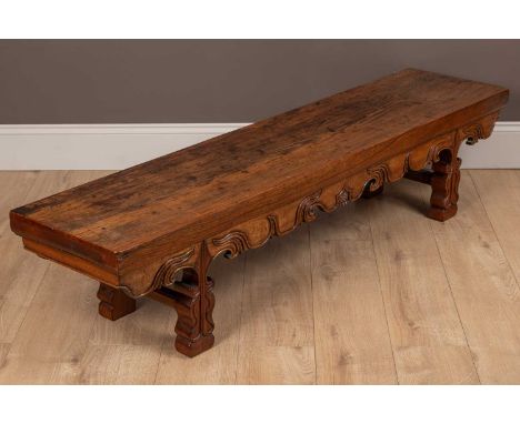 A Chinese pitch pine and hardwood long low bench with scrolling ornament and shaped legs170cm wide x 39cm deep x 37.5cm highQ