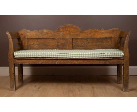 A 19th century Continental style pine bench with a shaped top rail above a panelled back and a cushion seat96cm high x 175cm 