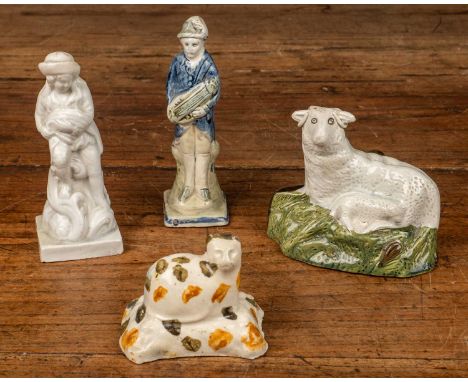 A group of 18th century pottery figures consisting of a cat in prattware colours resting on a cushion; a sheep on a mossy hil