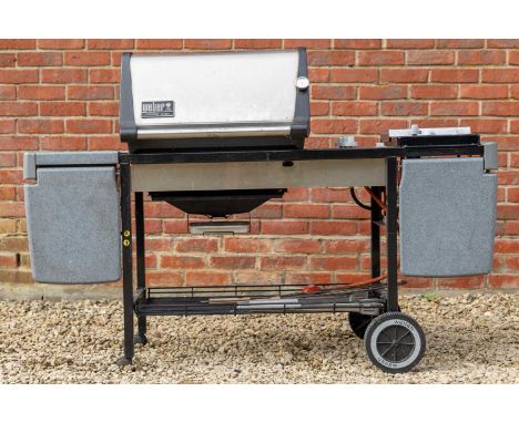 A Weber Genesis Gold barbeque, with three burners and a gas hob side burner; together with a collection of barbequing tool in