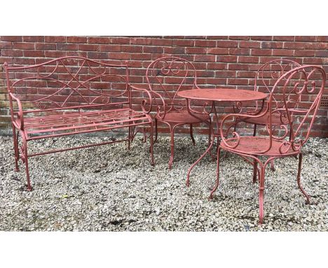 A red painted circular tripod table; together with three similar armchairs; and a wrought iron two seater benchthe table 72cm