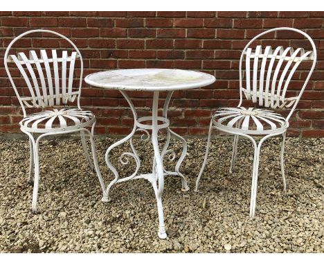 A white painted wrought iron bistro set with a circular table with scrolling tripod base and two French style chairsthe table