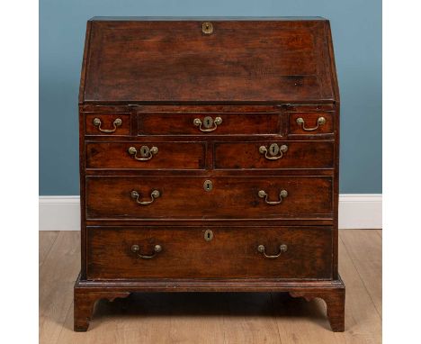 A George III provincial fruitwood bureau, the fall front enclosing a fitted interior with a central cupboard, drawers and pig