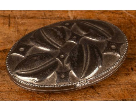 An early to mid-20th century Arts &amp; Crafts white metal oval snuff box with chased decoration of leaves amongst stars and 