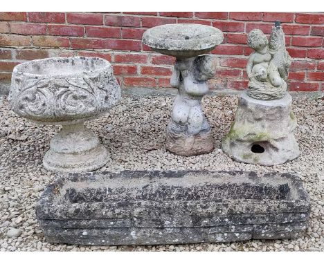 A collection of garden ornaments to include a stone trough; a cast reconstituted stone fountain in the form of a boy holding 