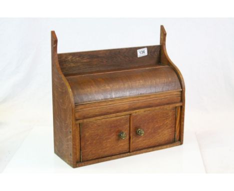 Early 20th century Oak Stationery Cabinet with curved hinged lid above two panel doors