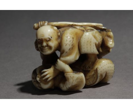 A mid 19th century Japanese netsuke from Edo period. Not signed. In carved ivory portraying two fighters, one of them holding